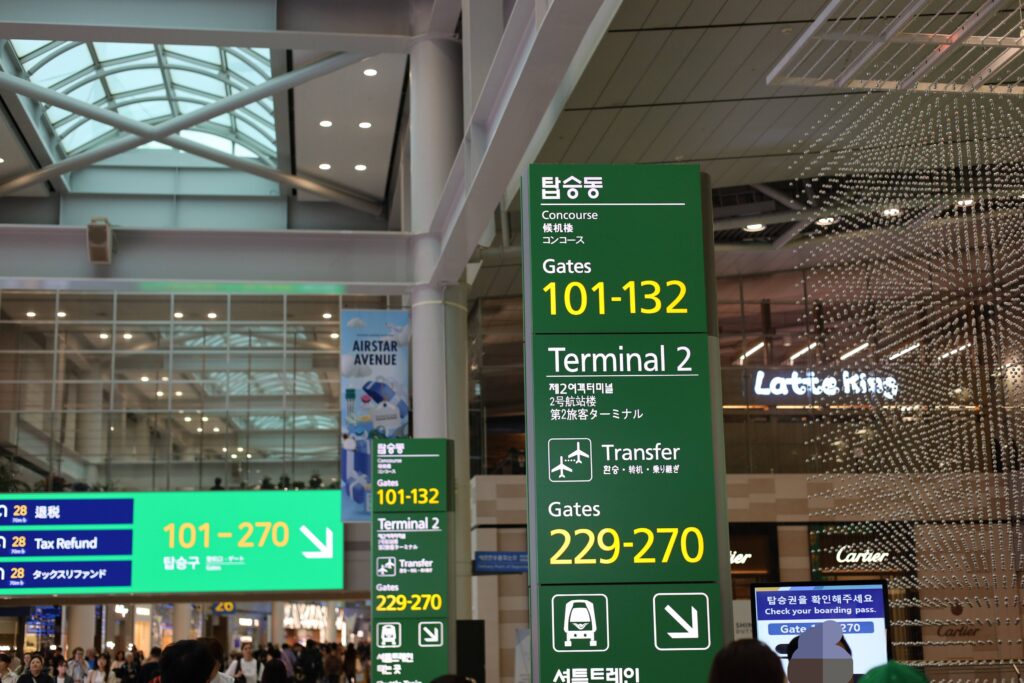 인천공항 탑승동과 게이트를 안내하는 선명한 녹색 표지판
