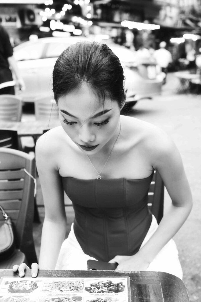 메뉴판을 보며 생각에 잠긴 모델의 감성적인 흑백 사진