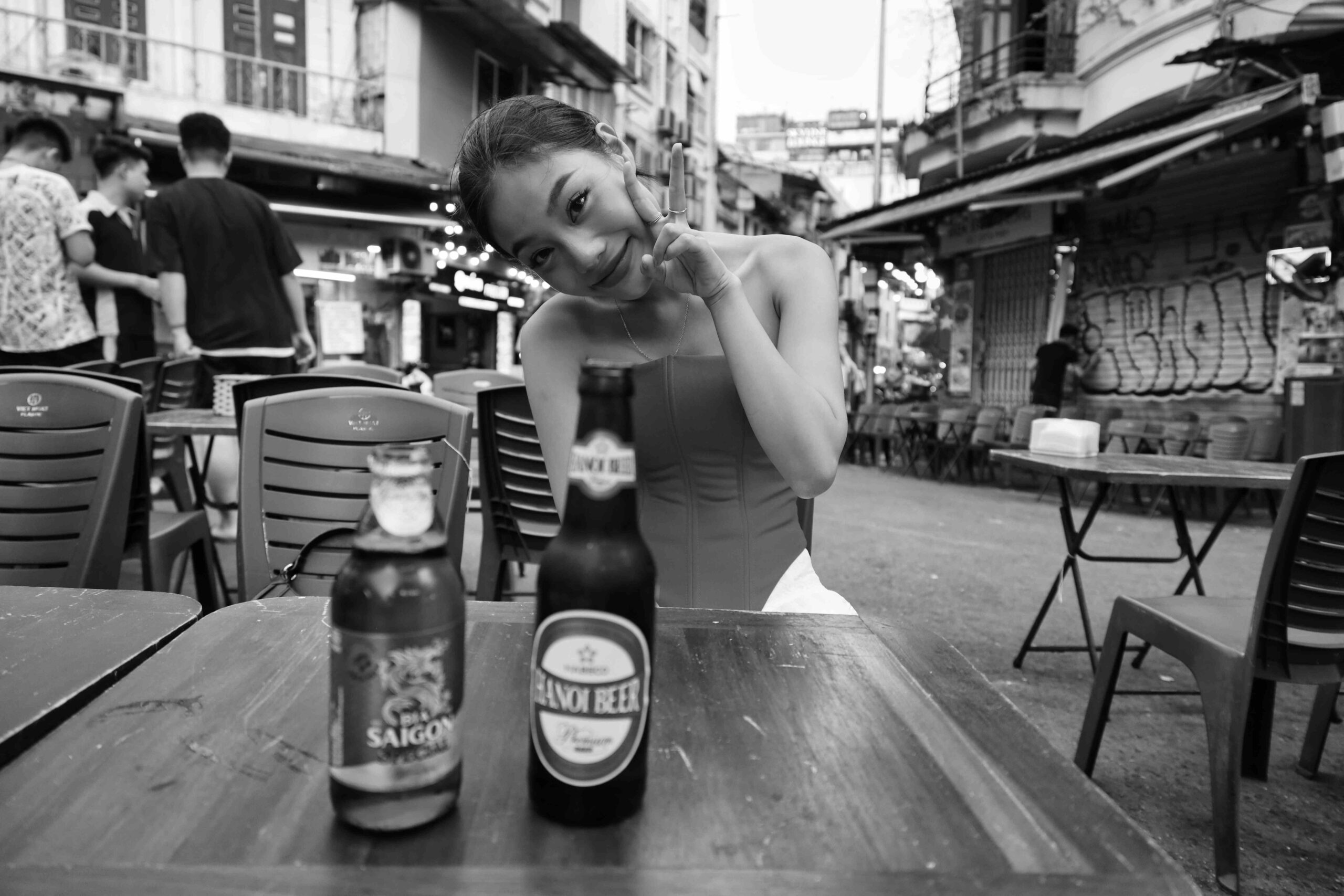 맥주병 앞에서 장난스럽게 포즈를 취하는 모델의 흑백 사진